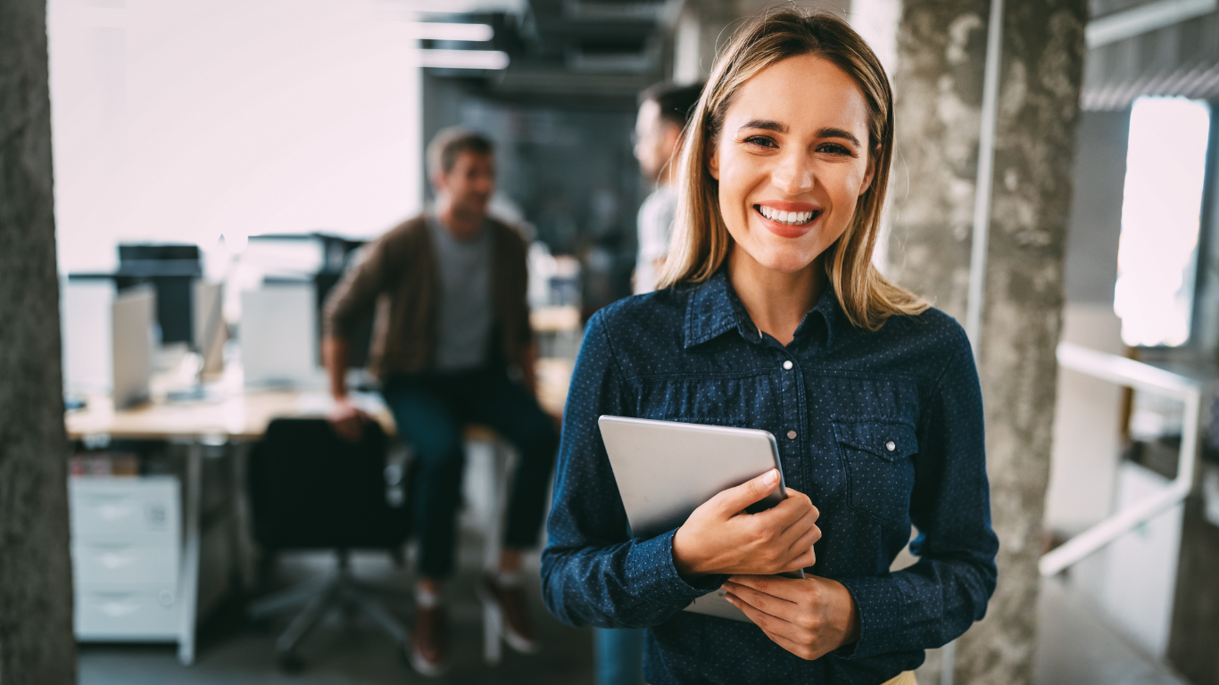 Empreendedora sorrindo em um escritório, representando novos negócios e a dúvida sobre quanto custa para abrir um CNPJ